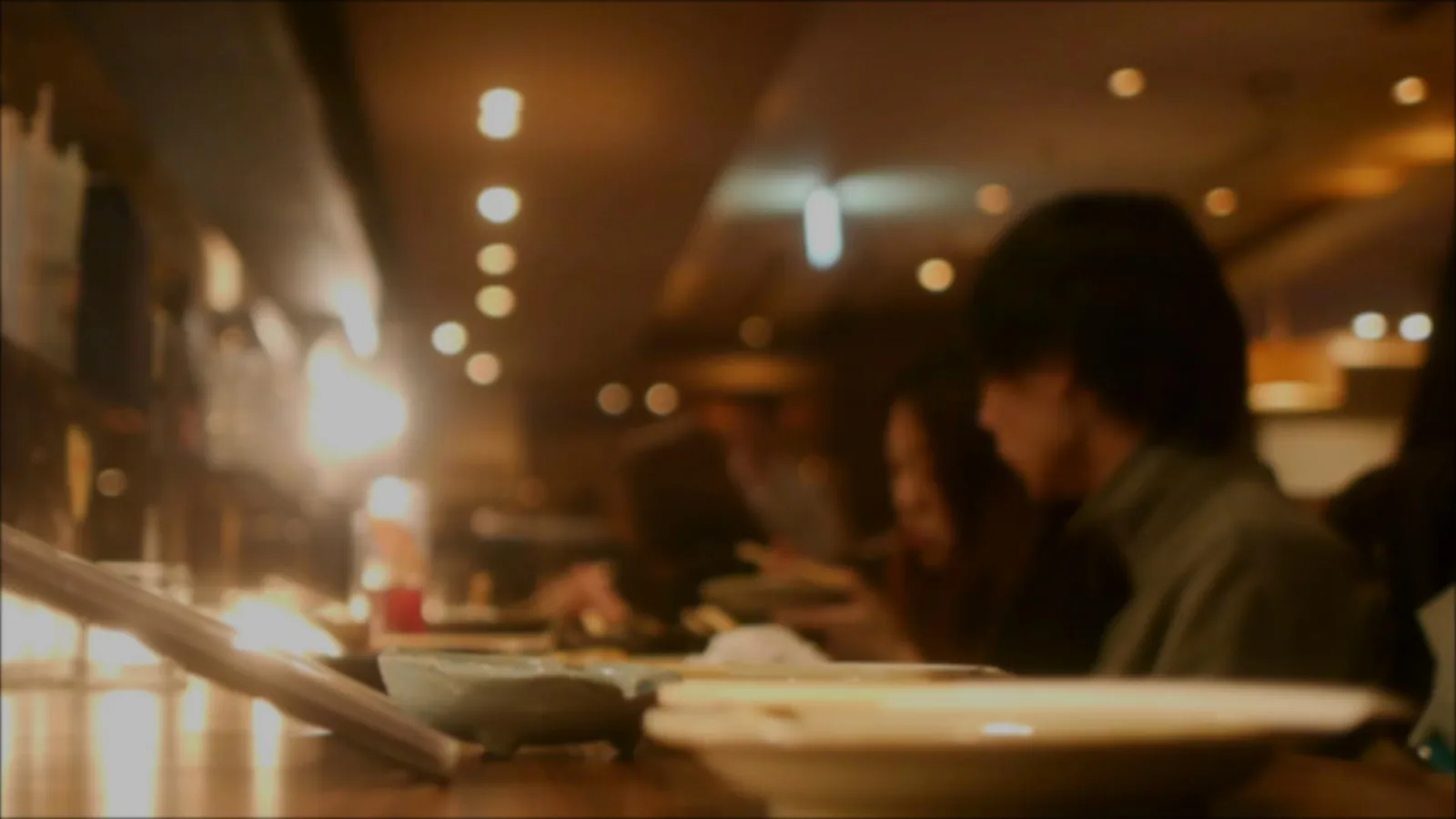 Warm dim restaurant interior with diners at low tables